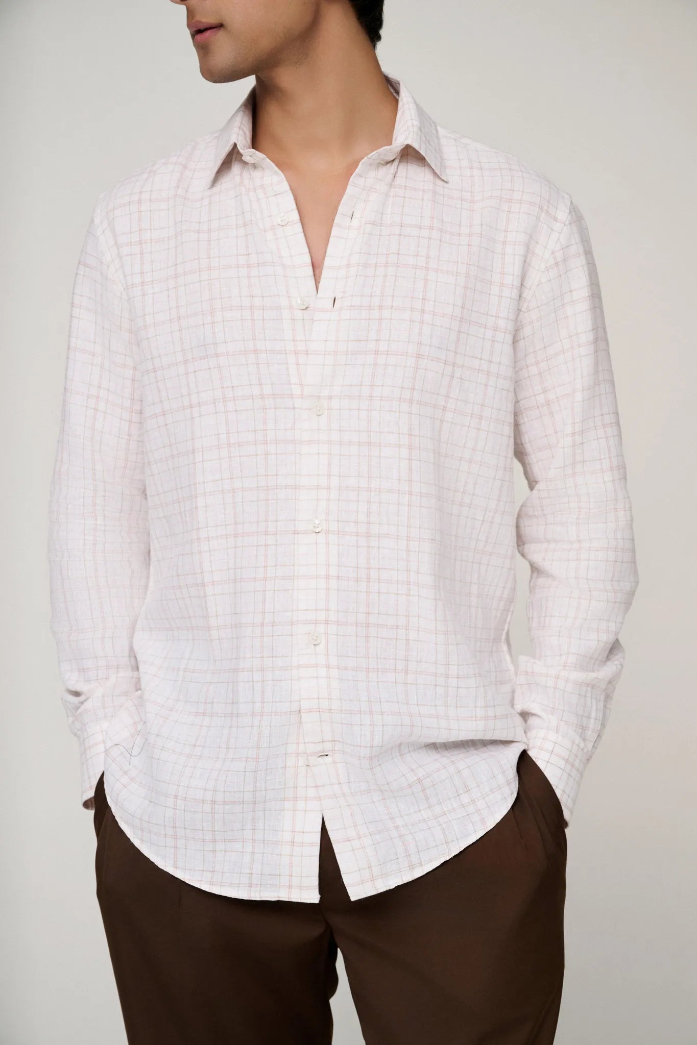 Detailed view of pink check linen shirt fabric texture.