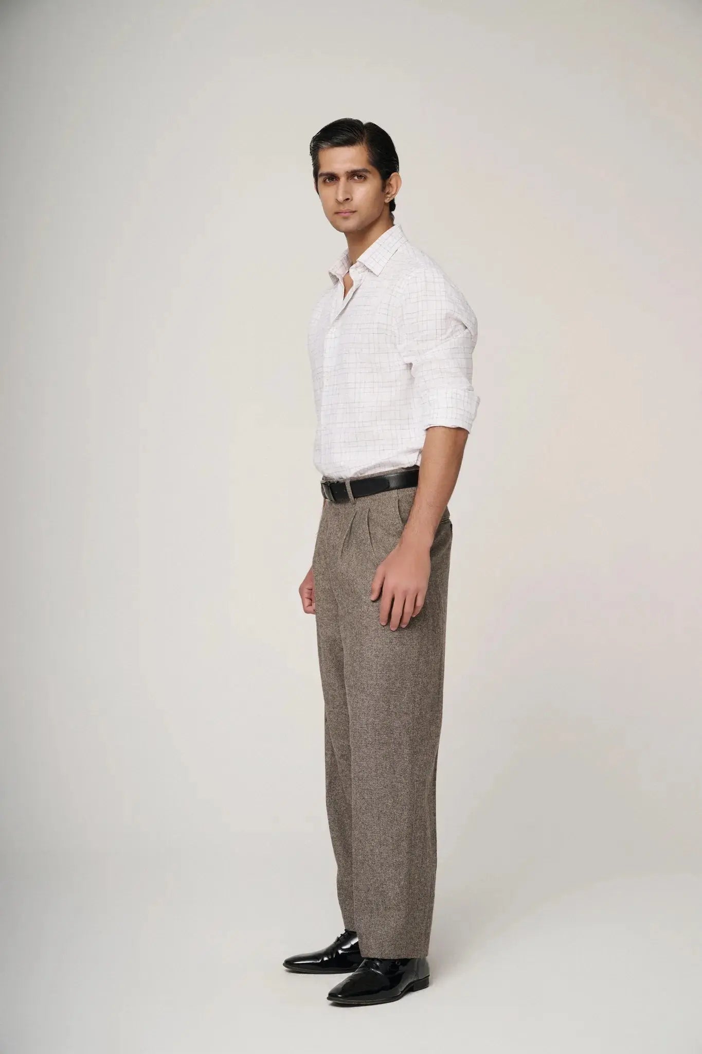 Side profile of model in white check linen shirt, showcasing fit.