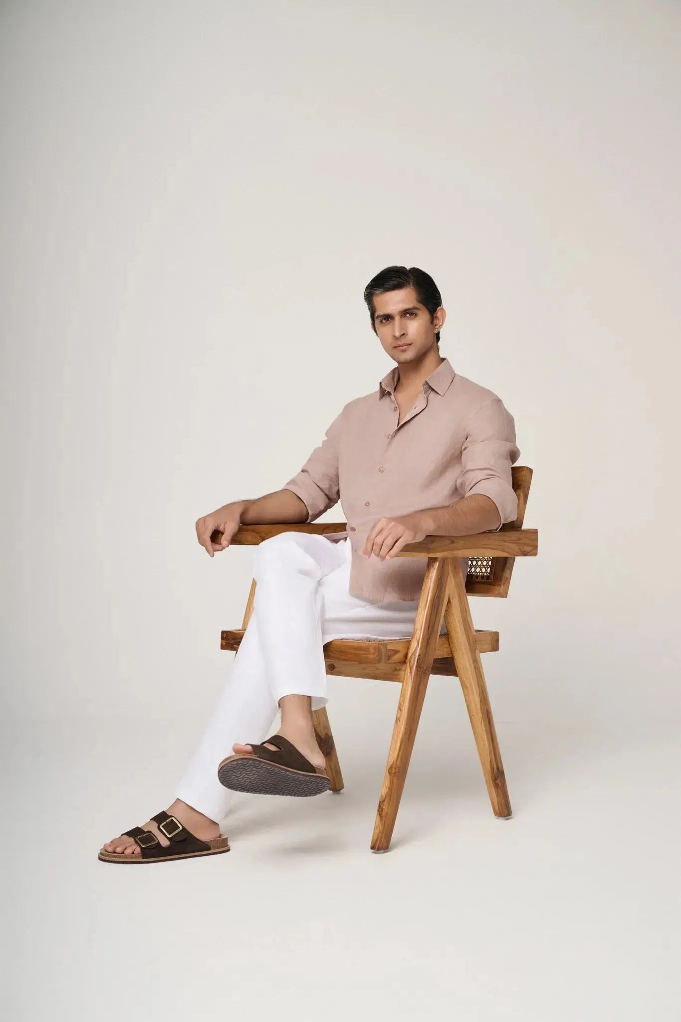 side profile of a seated model wearing a camel linen shirt