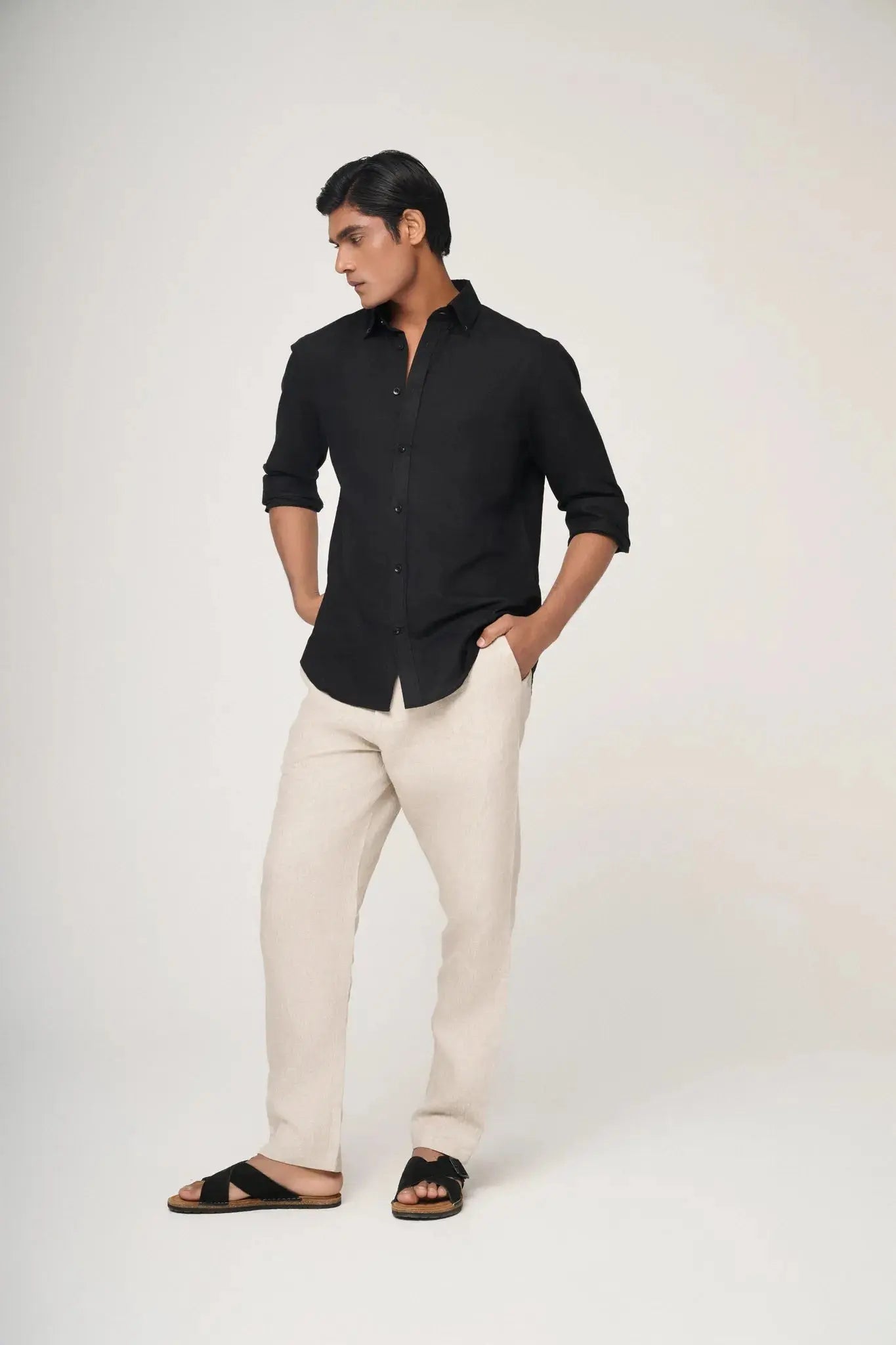 Black linen shirt paired with beige trousers.