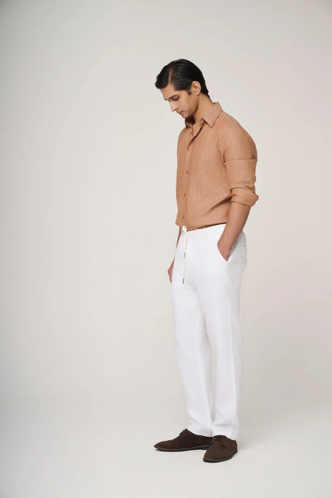 light brown linen shirt with sleeves rolled up 