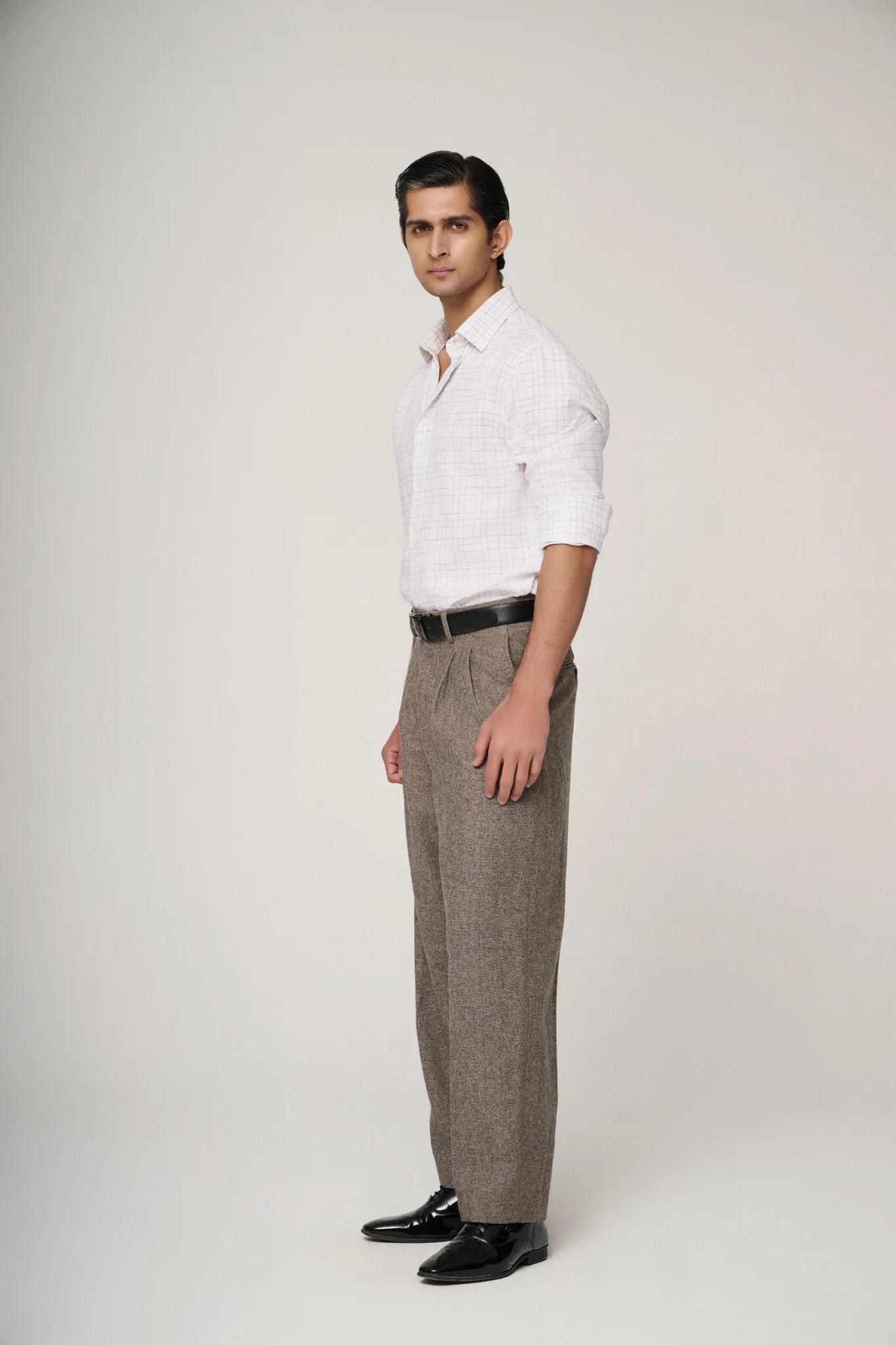 Side profile of model in white check linen shirt, showcasing fit.